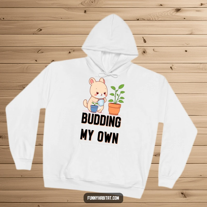 Funny hoodie depicting a content small animal character watering a small houseplant, perfect for casual wear and gifting.