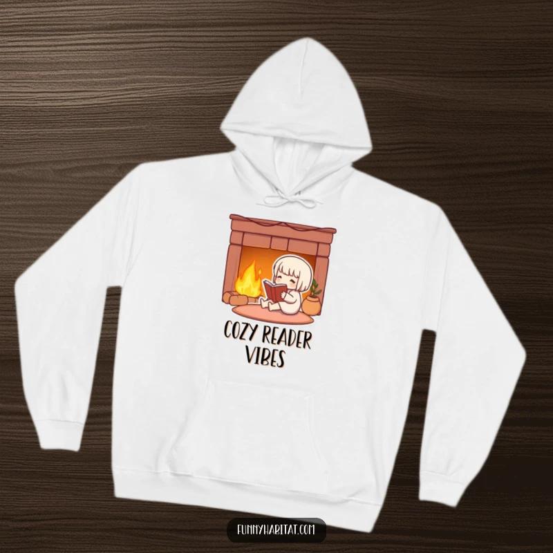 Funny hoodie with a cute character reading by a warm fireplace, evoking feelings of comfort and literary bliss.
