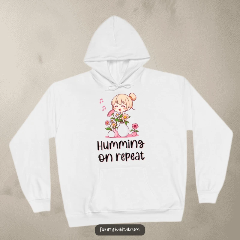 Funny hoodie depicting a character humming and arranging flowers in a vase, offering warm and humorous comfort.