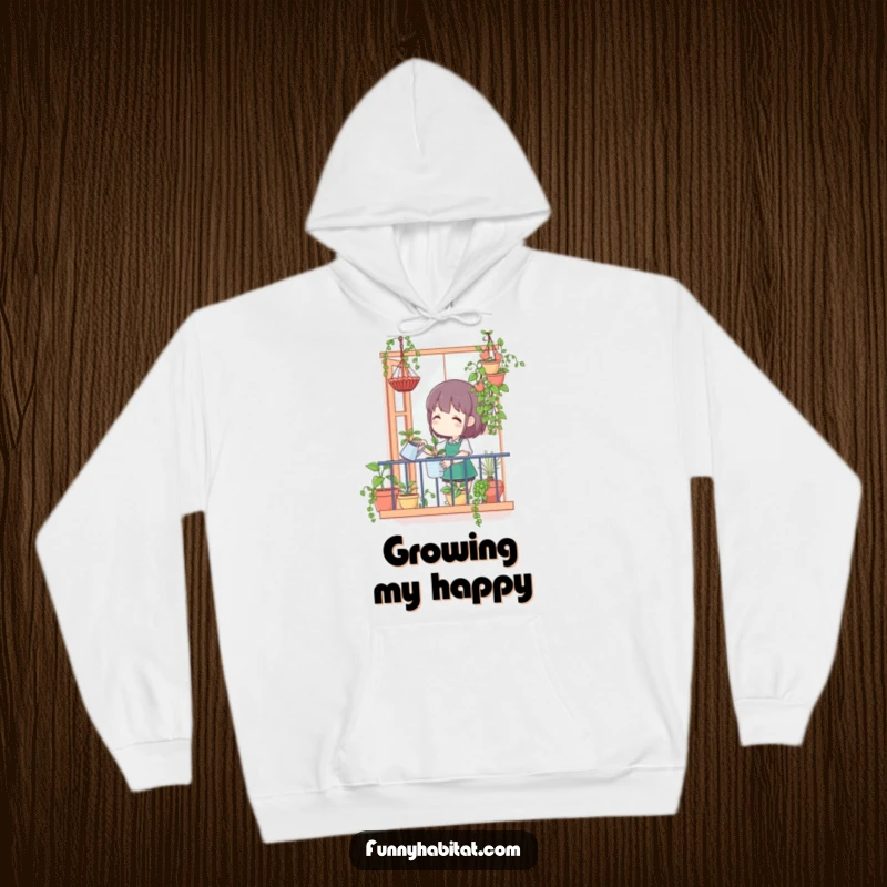 Funny hoodie showing a character happily watering hanging plants from a balcony, offering cozy comfort for plant enthusiasts.
